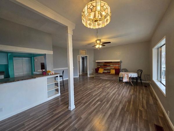 Spacious living room with wood flooring and a cozy seating area.