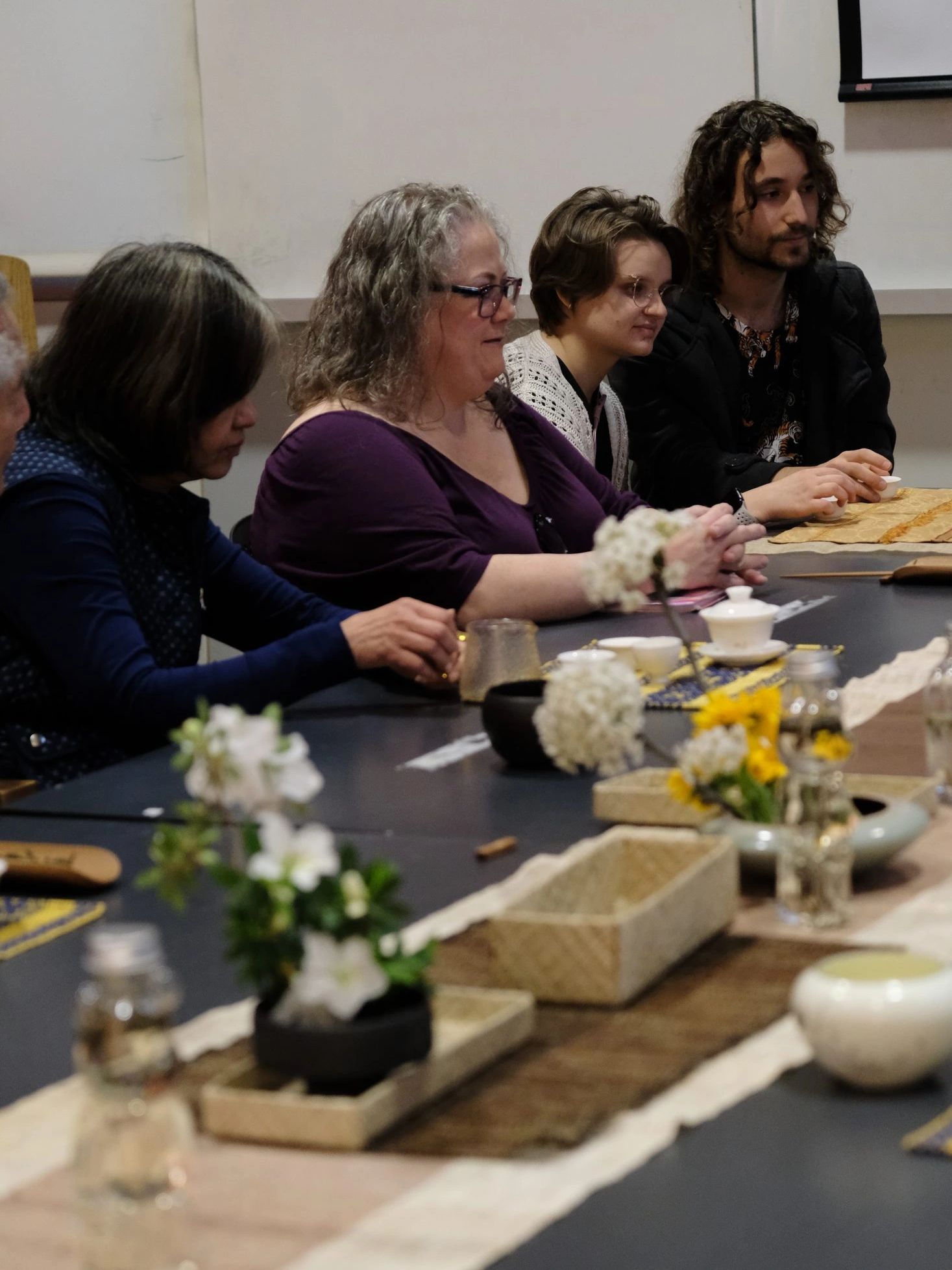 Participants seated around a shared tea table at an ACHEA tea gathering