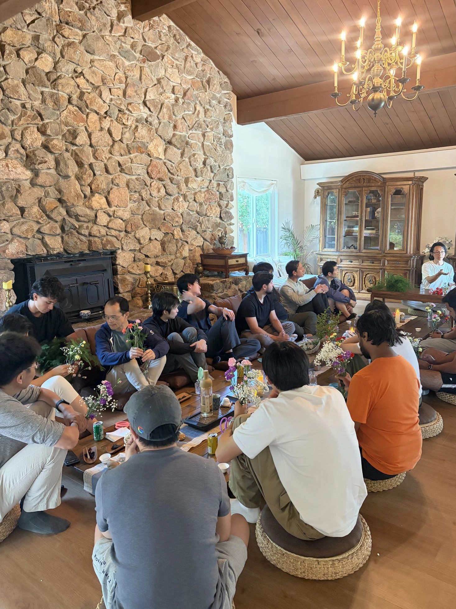A group seated on floor cushions during a tea and floral art cultural experience