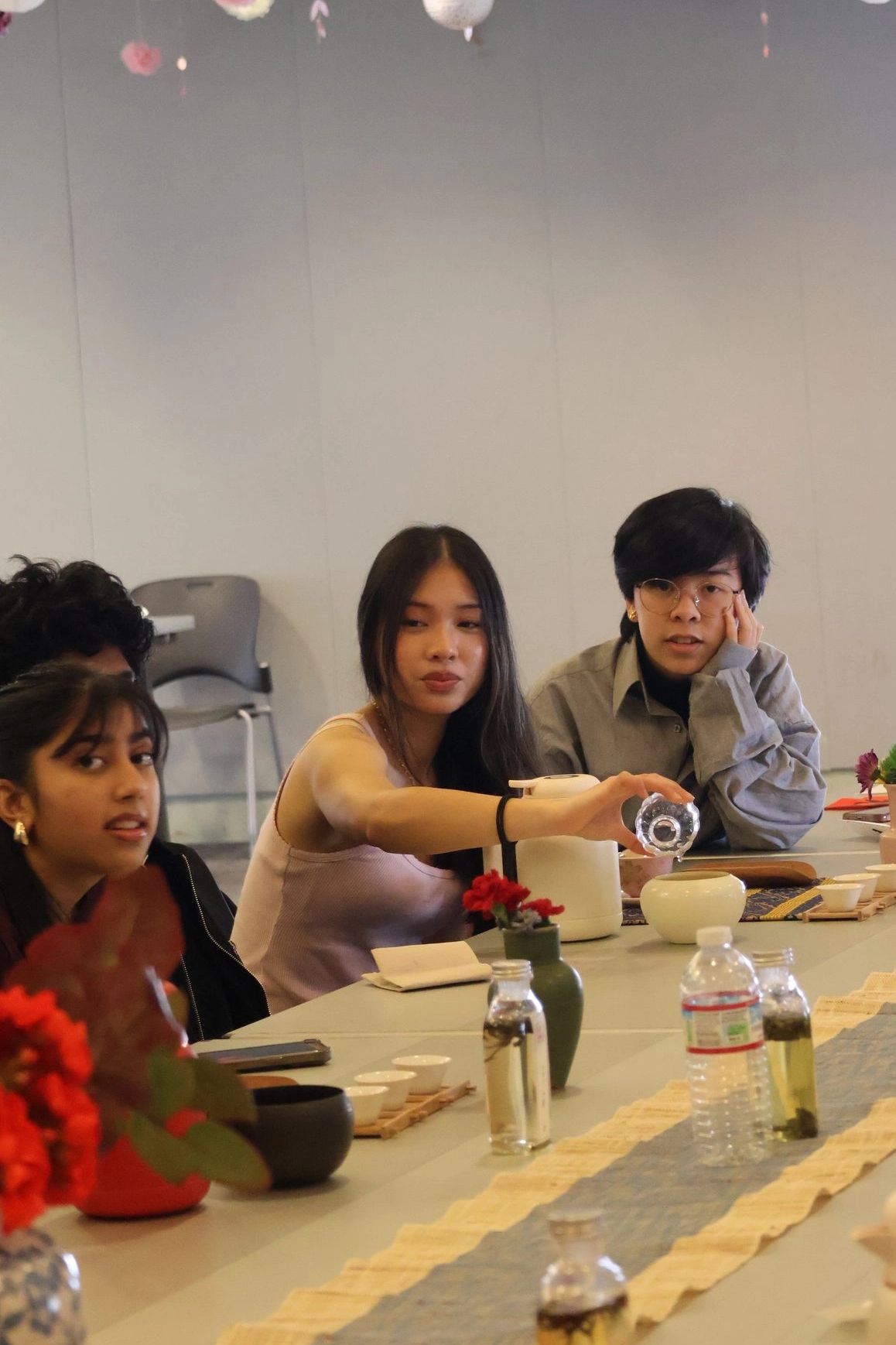 Young participants practicing tea preparation at an ACHEA program