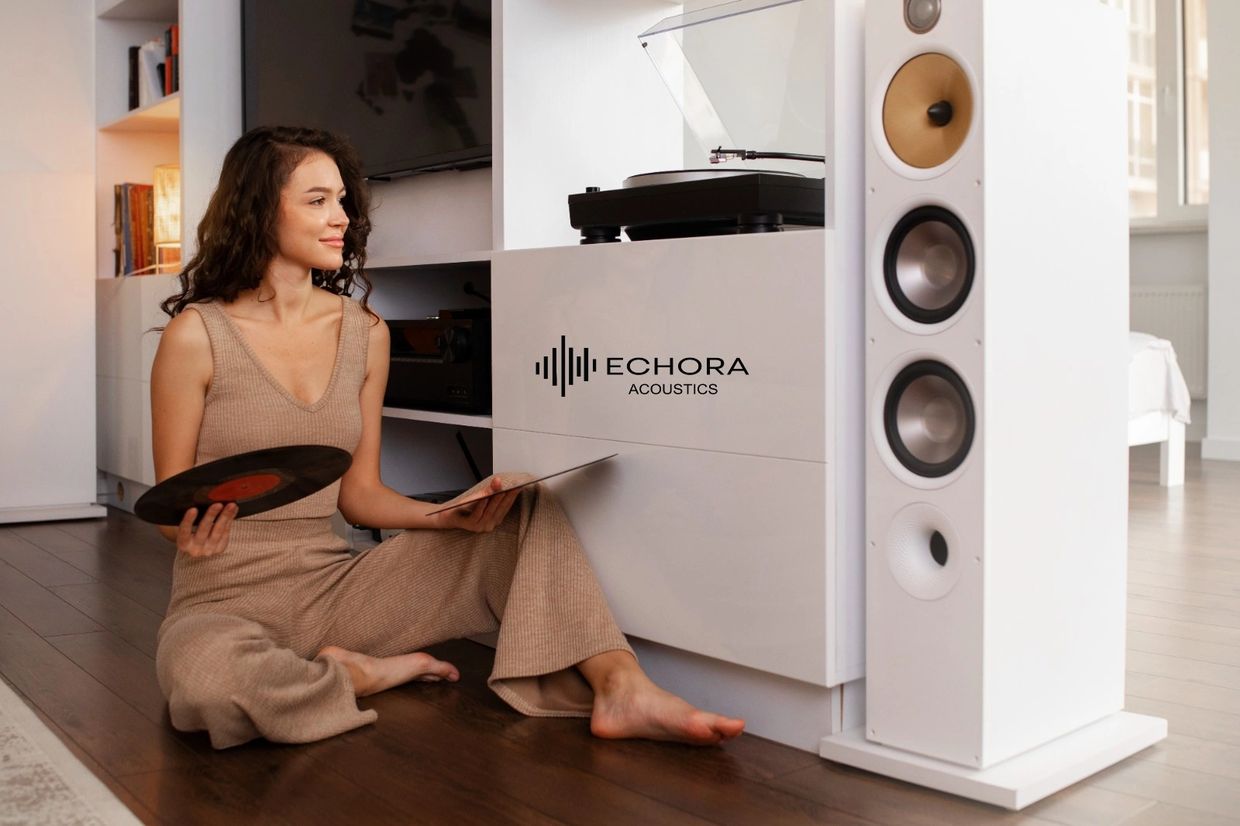 Woman enjoying vinyl records next to a turntable and large speakers.