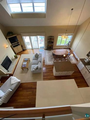 Bright, open living and dining space with hardwood floors and large windows.