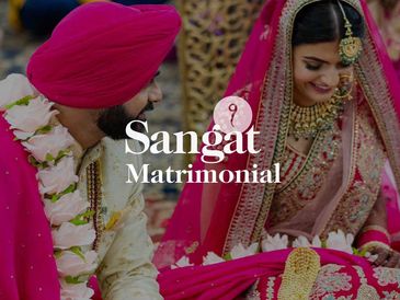 A joyful Indian couple dressed in traditional wedding attire.