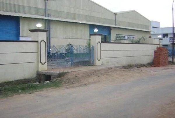 Warehouse entrance with dirt road and brick pile.
