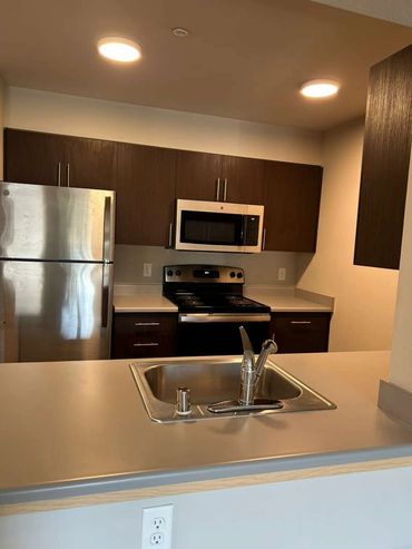 Modern kitchen with stainless steel appliances and wooden cabinets.