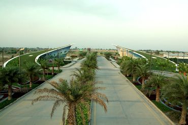 A modern road with greenery and uniquely designed overpasses in a serene landscape.