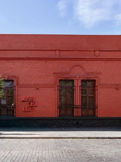 Red exterior of Museo Casa Kahlo with clear blue sky.
