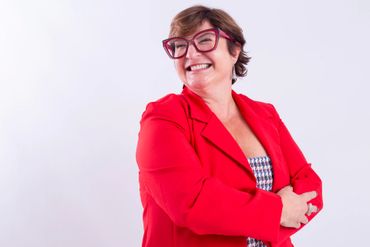 mulher de braços cruzados sorrindo para o lado