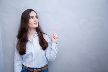 mulher com expressão surpresa apontando para o lado