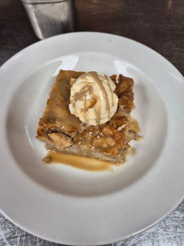 Apple dessert with ice cream and sauce.
