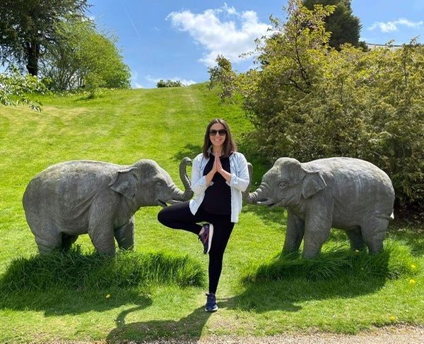 yoga pose with elephant sculptures