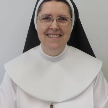Une religieuse souriante en habit traditionnel.