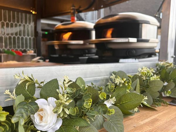 A decorative green garland with white flowers on a wooden counter.