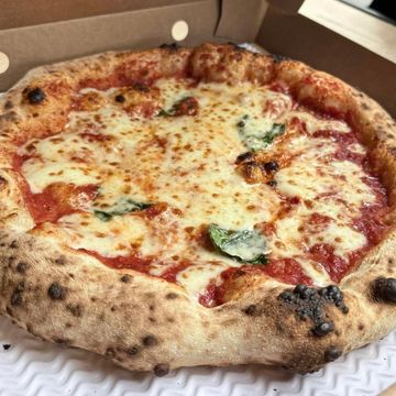 A freshly baked Margherita pizza with melted cheese and basil.