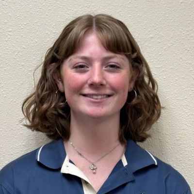 Young woman with wavy hair smiling.