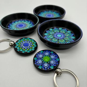 Mandala-themed keychains and dishes on a white background
