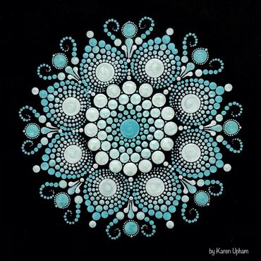 Intricate blue and white dot mandala on black background.