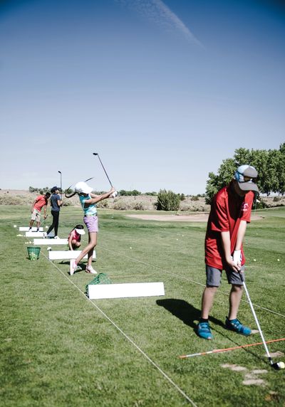 Golfers practicing and receiving golf lessons