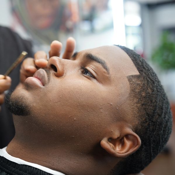Man getting a precise haircut at a barbershop.