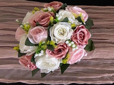 Bouquet of pink and white roses with greenery.