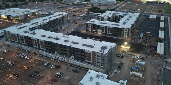 Aerial view of large apartment complex under construction at dusk.
