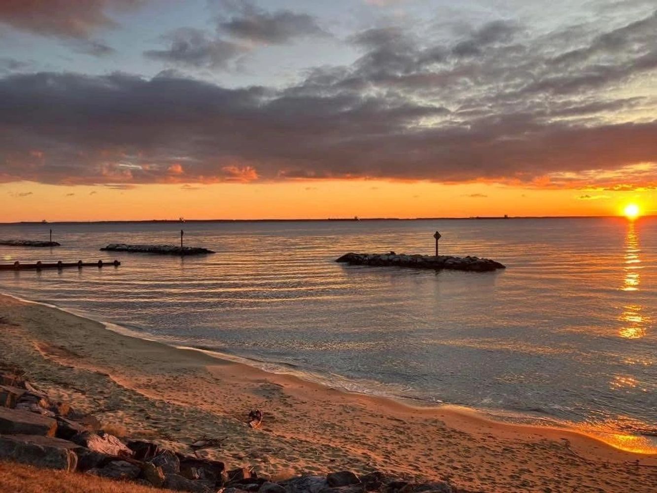 Sunset over calm beach waters with rocks and clouds. Inhale the Beauty Exhale the Darkness