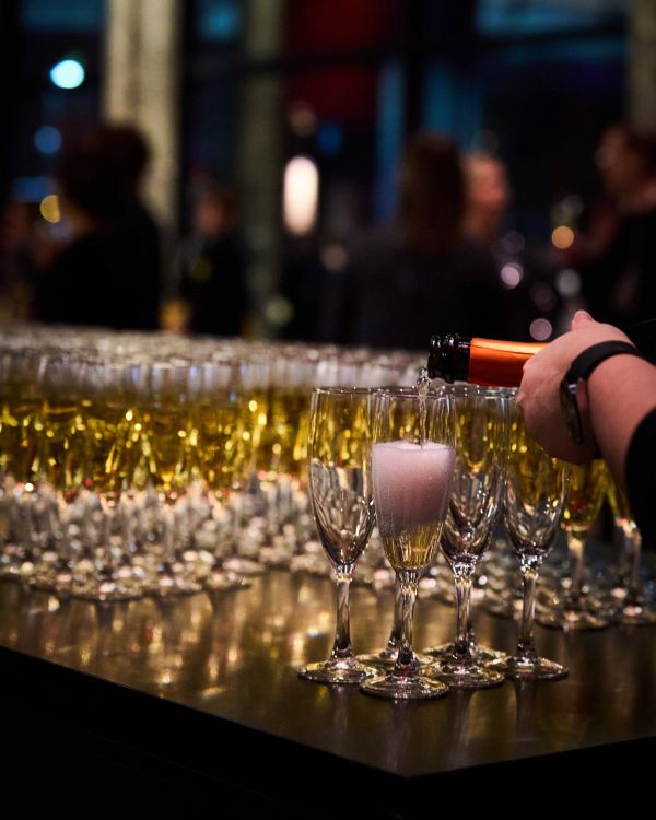 Champagne being poured into glasses at a party.