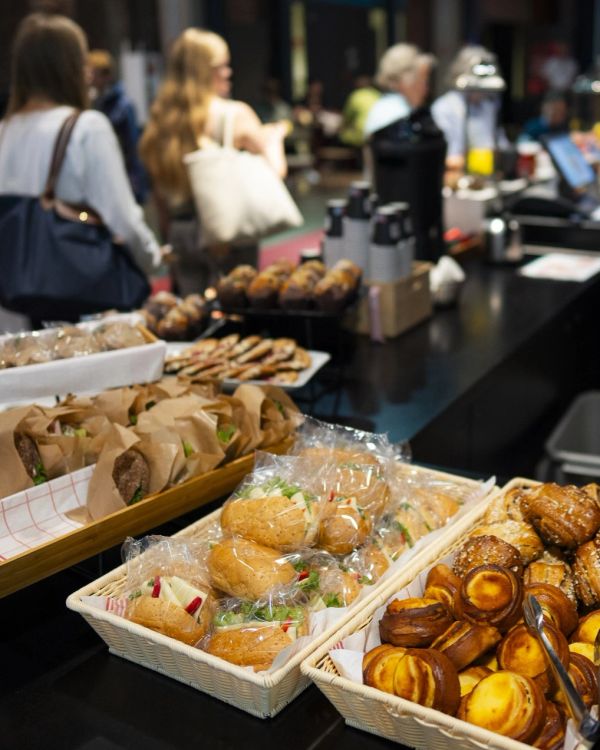 Bakery table with sandwiches and pastries.
