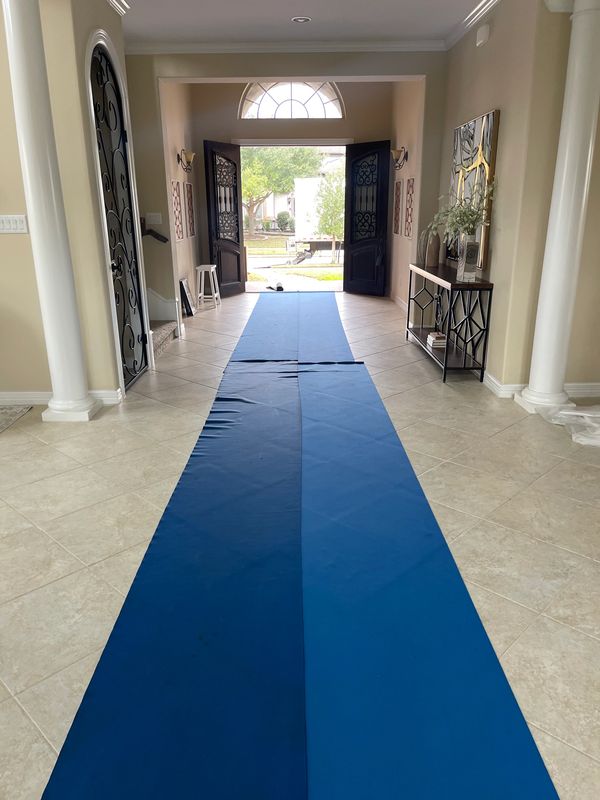 Open double doors with a blue carpet runner leading outside.