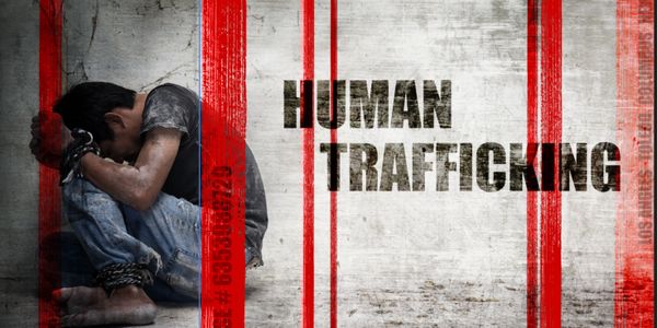 A bound child sitting in distress, symbolizing human trafficking.