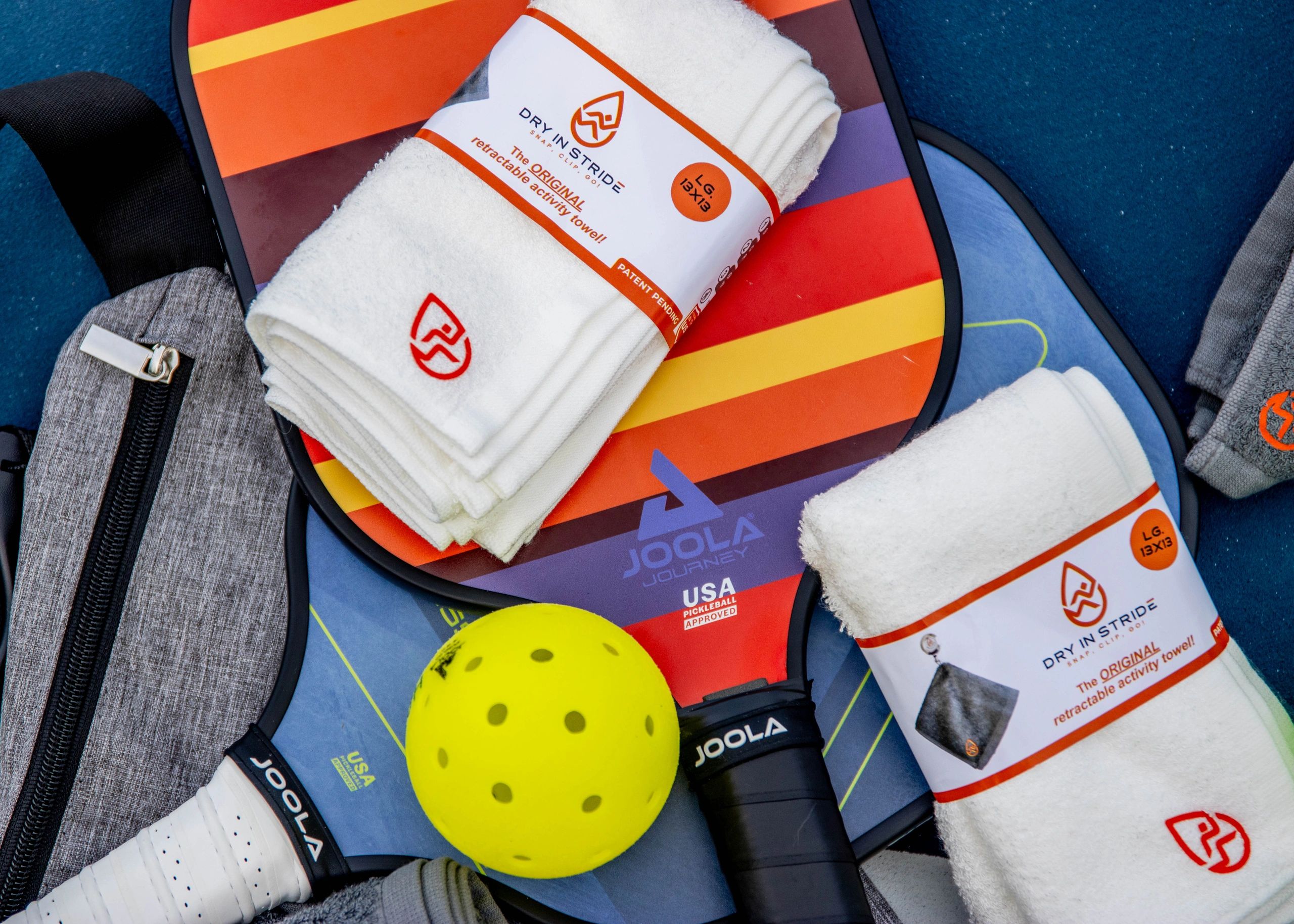 Dry in Stride retractable towels overlaid on pickleball rackets.