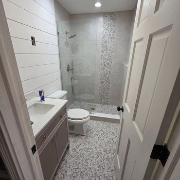 Modern bathroom with pebble tile flooring and walk-in shower.