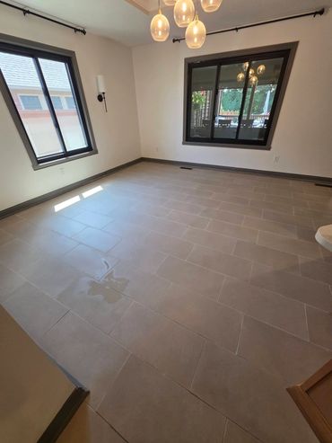 Empty room with tiled floor and windows.