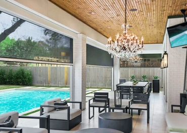 Modern outdoor patio with pool and chandelier.