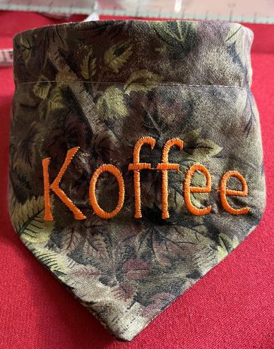 Close-up of fabric with 'Koffee' embroidered in orange thread.