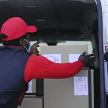 A worker loads boxes into a delivery van.