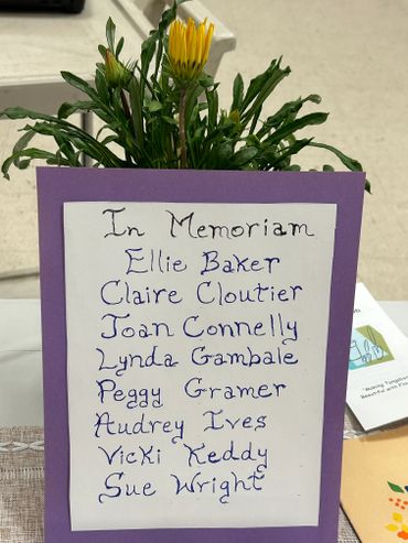 Memorial card with handwritten names and yellow flower.