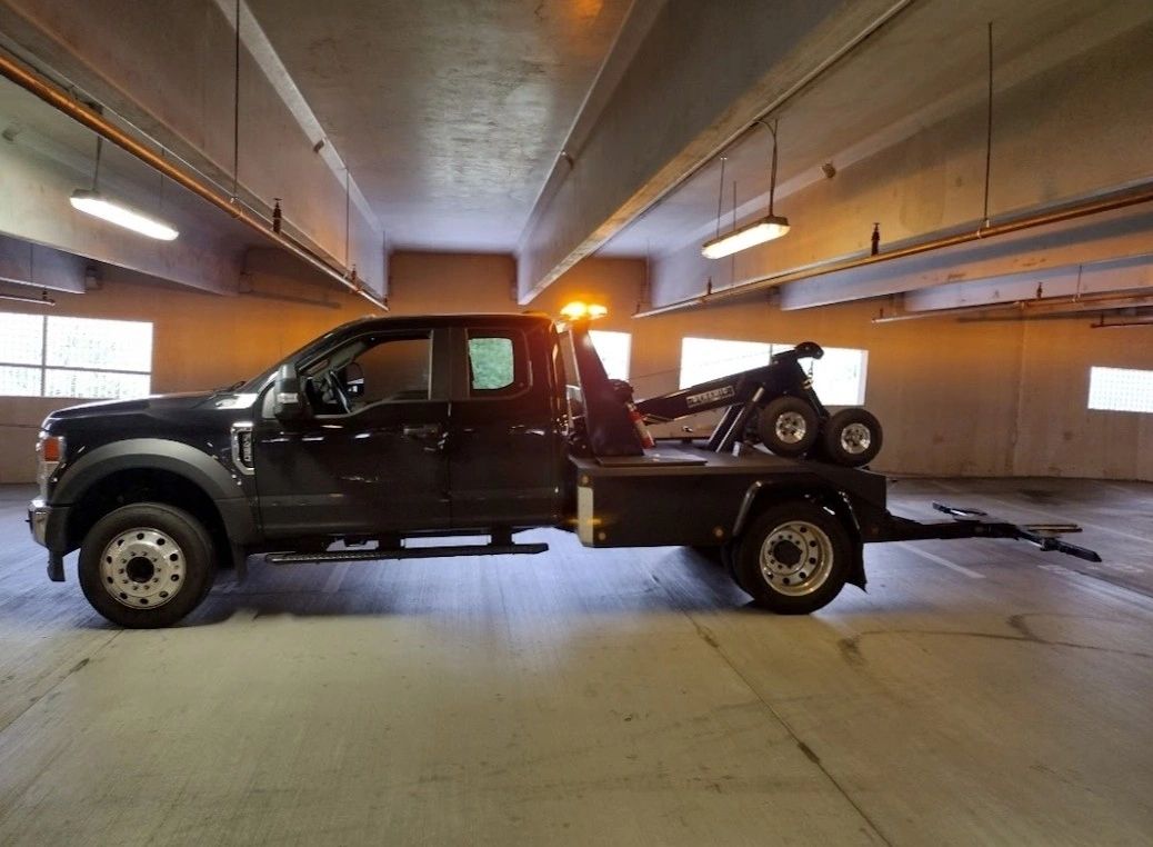 Black tow truck in a service bay.