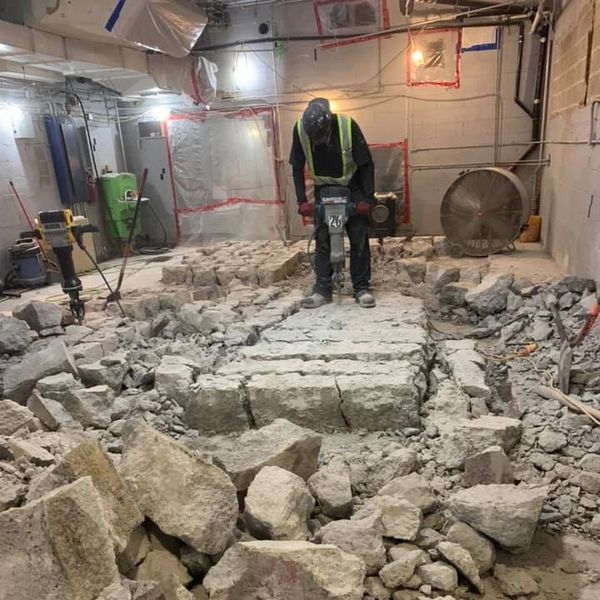 construction worker jackhammering concrete pad