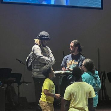 A group engaging in a discussion under a screen about creating memorable Christian experiences.