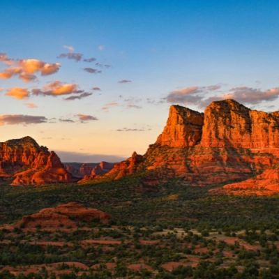 Sunset over red rock formations in a desert landscape.