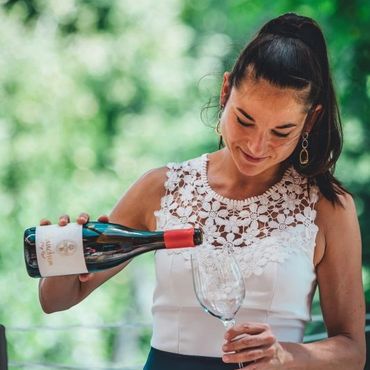 Alenka som jobbar på Sanctum wine häller upp en flaska rött vin
