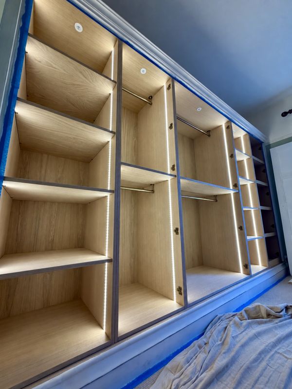 Empty wooden closet with built-in lighting.