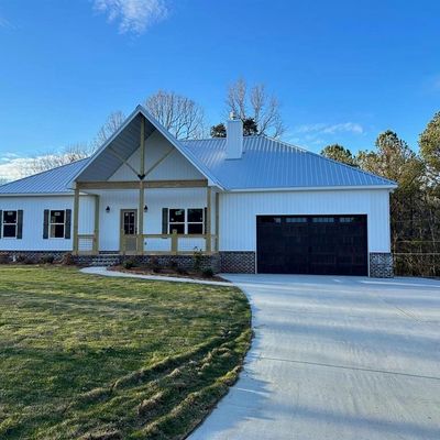Modern white house with a spacious driveway and garage.