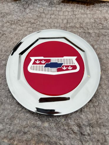 Wire wheel hub cap with red chevy bell air badge