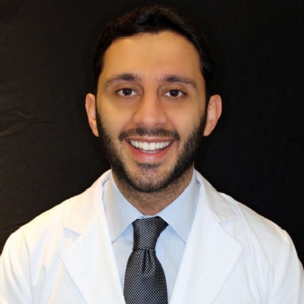 a Persian man in with a tie and clinical lab coat