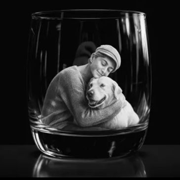 Black and white image of a woman hugging a dog inside a glass.