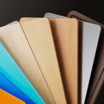 A fan of laminate flooring samples in various colors and textures.