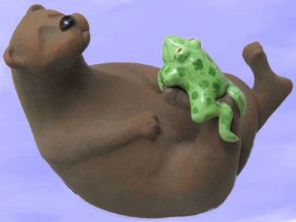"Otterly Ribbiting" is a whimsical sculpture portraying a river otter and his froggy friend lazing a