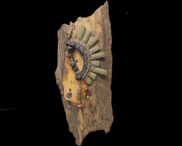Primitive clay and mixed media art, "Warrior Shield" is mounted on spalted wood and has a substantia